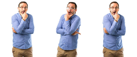 Middle age handsome man scared in shock, expressing panic and fear over white background