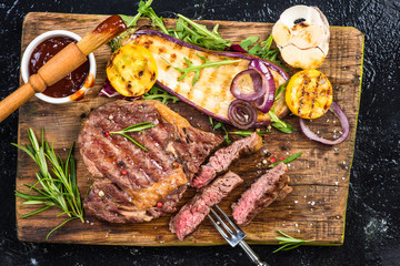 Pieces of grilled medium rare steak with vegetables