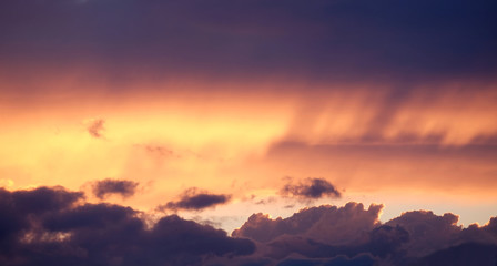 Landscape woth beautiful purple sunset with colorful surreal dark clouds on fiery sky in the evening panoramic view