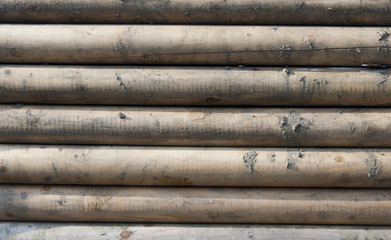 The pattern of a wall made up from wooden trunks