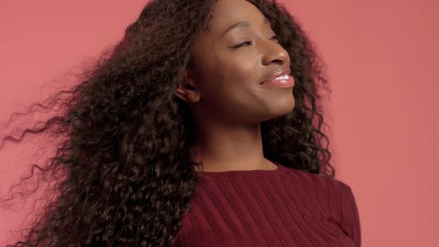 Beauty mixed race african american woman portrait in pink background with wind in hair