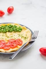 Omelette with green peas and cherry tomatoes. Protein breakfast