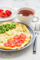 Omelette with green peas and cherry tomatoes. Protein breakfast