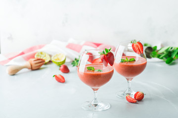 Alcohol cocktail with vodka, strawberry, lime, basil and ice