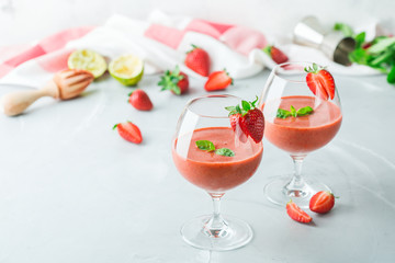 Alcohol cocktail with vodka, strawberry, lime, basil and ice