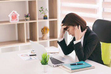 the women are stressed at work in the office. Asian beautiful woman stressful and headache with laptop computer. Young business woman with headache at office, feeling sick at work.