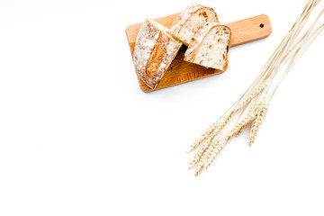 Homemade fresh bread sliced on cutting board on white background top view copy space