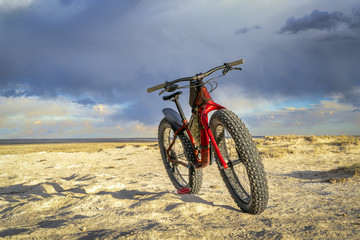 Fototapeta na wymiar fat bike in badlands with storm clouds