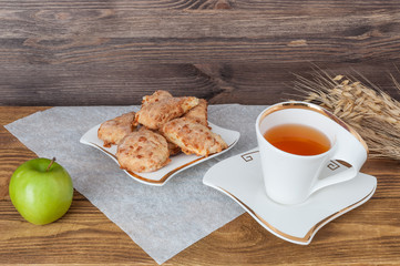 Cup of tea, Apple and wheat on a wooden background