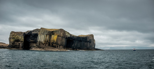 Panoramic view on Staffa Island and boat off the coast of Scotland