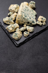 Slice of French Roquefort cheese on stone board
