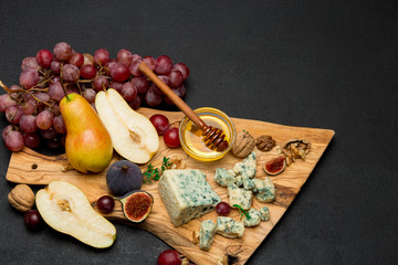 Slice of French Roquefort cheese and pear on wooden board