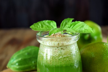 Green smoothie in a glass jar sprinkled with brans decorated with basil