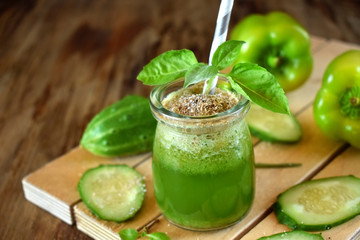 Green smoothie in a glass jar sprinkled with brans decorated with basil