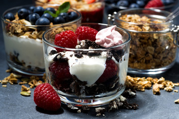 various desserts with berries and cream on dark background, closeup