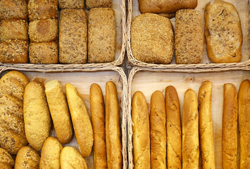 Different kinds of bread in baskets top view.