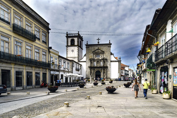Fototapeta na wymiar Street of Santo Domingo, in the center of town with facade of the church of Saint Domingo in the background and curious iron flowerpots with flowers on the ground