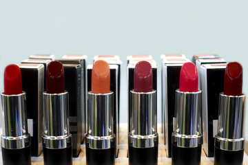 Cosmetics. Red lipsticks of different shades are open and exhibited in rows