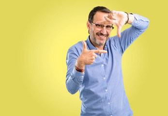 Handsome middle age man confident and happy showing hands to camera, composing and framing gesture
