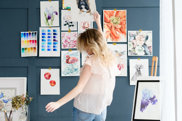 creative art lifestyle. drawing hobby and self expression. painter dancing against the wall with her artwork. watercolor drawing assortment