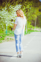 Beautiful blonde pregnant woman walking in the green garden