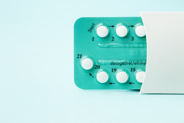 Pack of oral contraceptive pills with instructions. Blister in white case on blue background