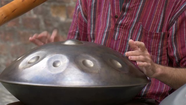 Close up of hands playing a hang drum 