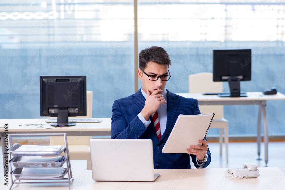 Wall mural young handsome businessman employee working in office at desk