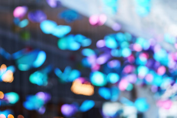 Blurred beautiful and great installation-decoration in the form of bright butterflies in the free spaces of the modern shopping center mall in the city                            