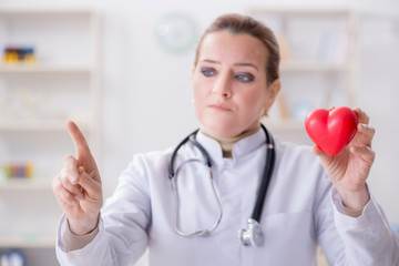 Cardiologist with red heart in medical concept