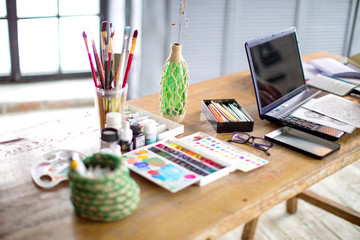 Conceptual image of graphic designer workplace, with a pen tablet, a computer and some color swatches