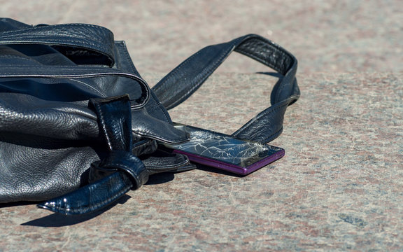 Modern smartphone dropped out of the women's handbag and crashed screen. - Powered by Adobe