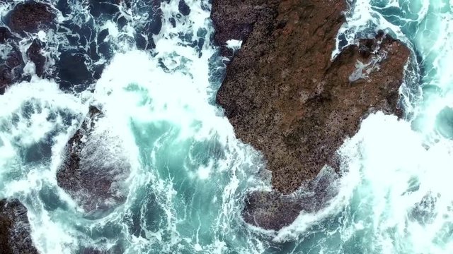 Aerial shot of ocean waves crashing coastline. Portugal