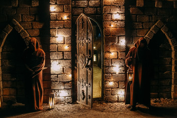 Two guards entrance castle open door night lanterns