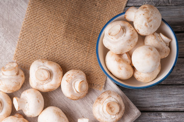 Fresh champignons on a cutting board and in a bowl 