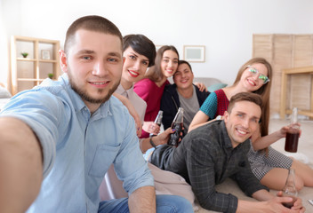 Fototapeta premium Szczęśliwi przyjaciele biorąc selfie w pomieszczeniu