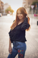 Obraz premium beauty girl dressed in denim and black shirt with orange hair in street
