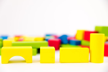 Colorful wooden building toy blocks isolated on a white background