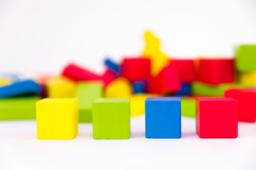 Colorful wooden building toy blocks isolated on a white background
