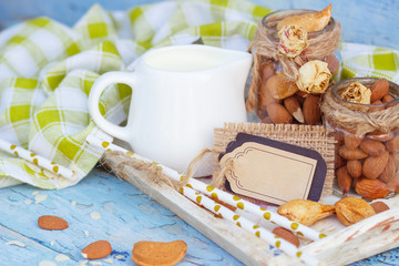 Almonds and jar with milk on the wooden tray