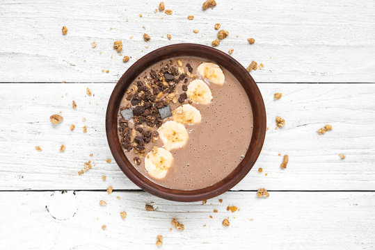 chocolate banana protein smoothie bowl with granola. top view