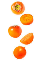 Falling sweet perssimon fruits isolated on white