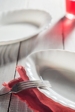 White plates and a red juice on a wooden table