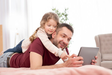Fototapeta premium Entertaining. Cute pretty little girl smiling and spending time with her daddy
