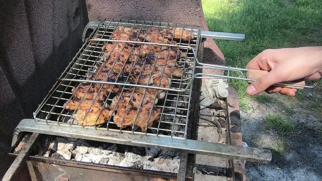Chicken meat wings that turn over on a barbecue grill.Meat is fried in Mangal Barbecue grill. Chicken meat on the gril 