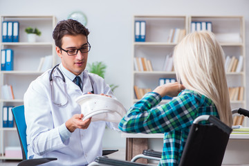 Disabled woman in wheel chair visiting man doctor