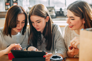 Three women browsing internet using tablet pc