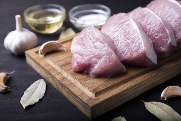 Raw pork fillet. Slice meat on cutting board