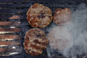 Preparing burger patties on a grill outdoors