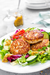 Cutlets and fresh vegetable salad on white plate. Fried meatballs with vegetable salad